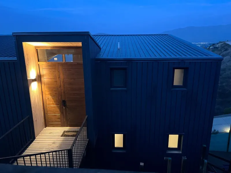 Fachada y acceso iluminado de una de las casas al anochecer