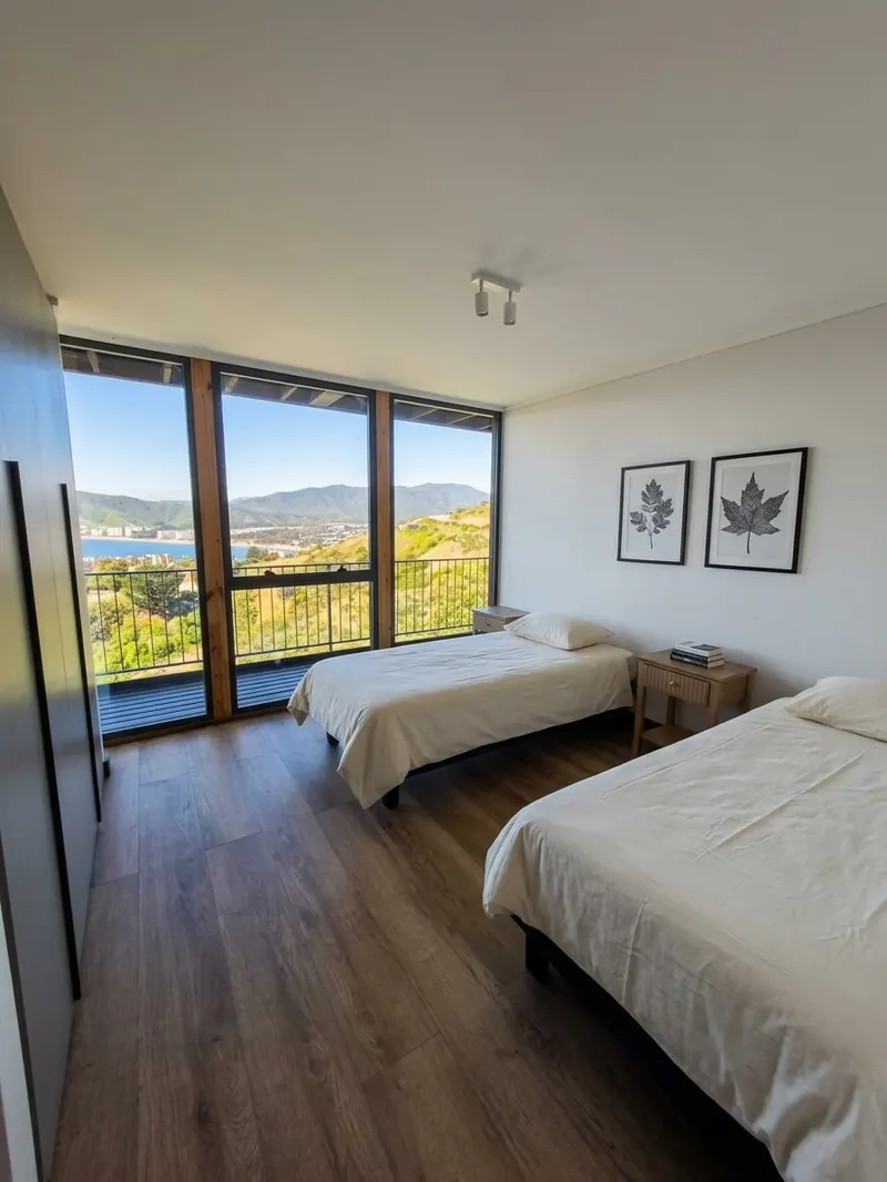 Dormitorio con dos camas individuales y ventanal hacia la bahía